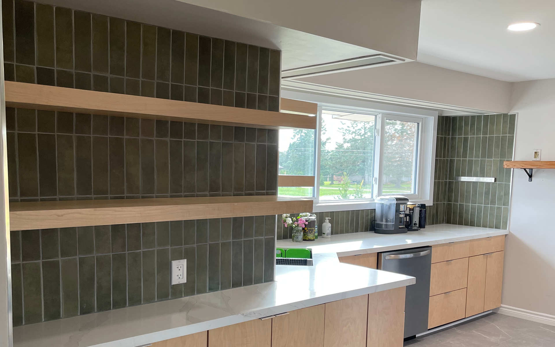 A modern kitchen with kitchen, stone or stone-look countertop and green tiles. A London Ontario kitchen renovation / new kitchen / home renovation project by Brothers Construction 3 Inc.